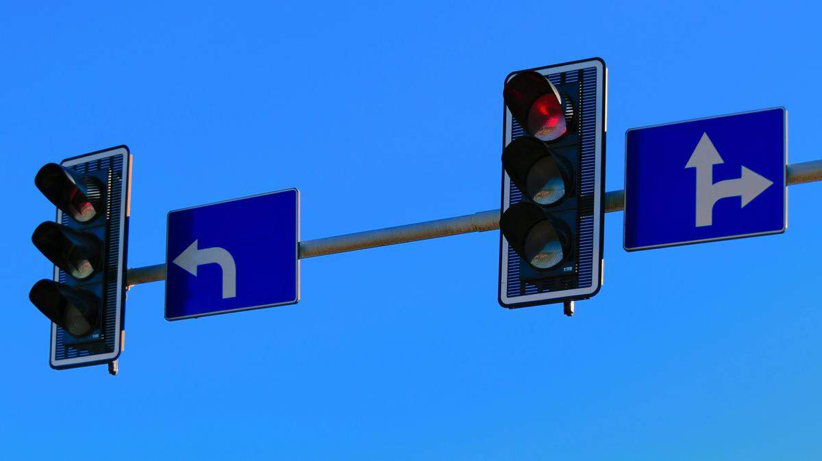 A left-turn sign at a traffic light.