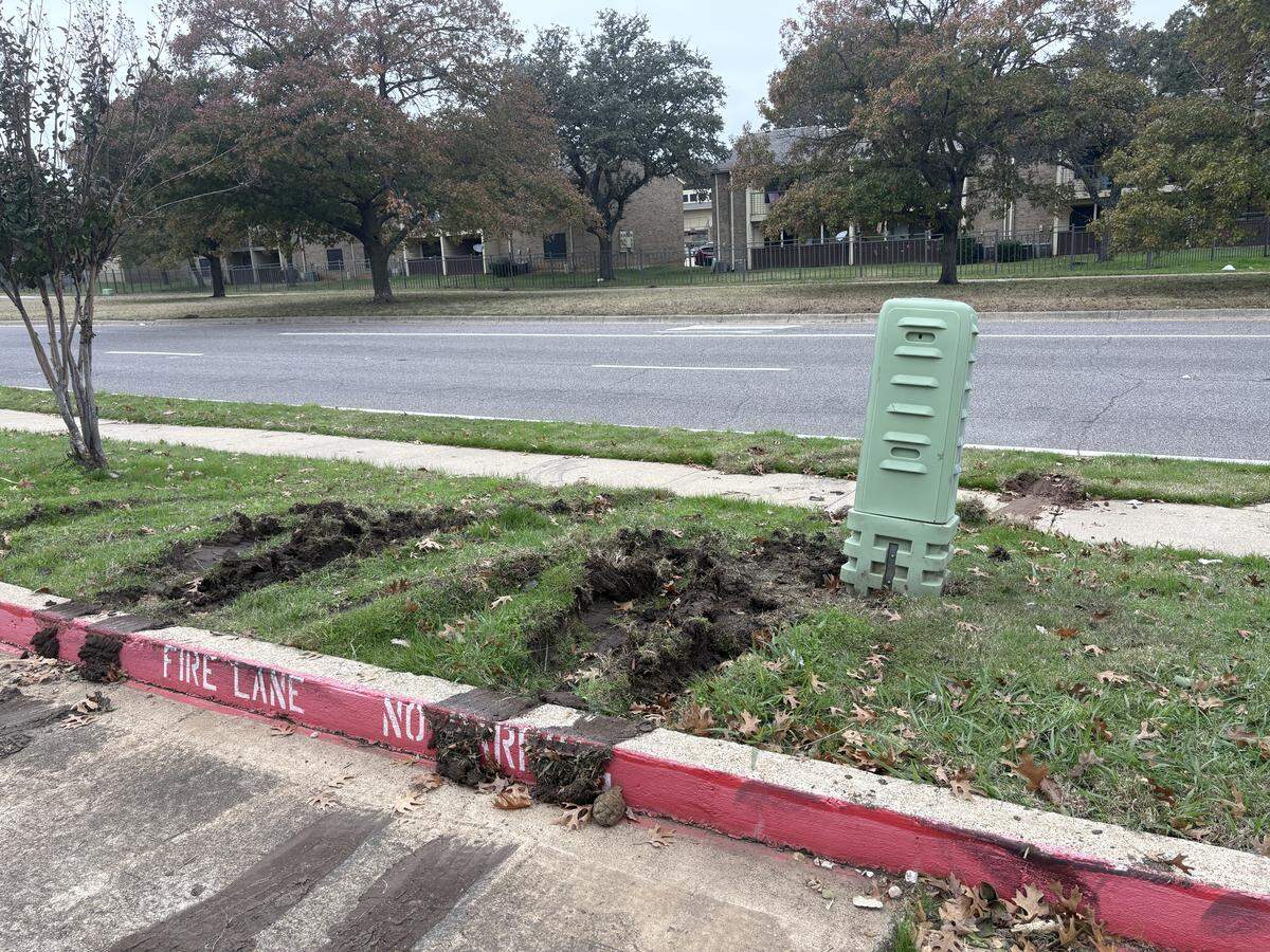 Tire tracks show a pickup truck apparently drove over a curb before crashing into an apartment off Sycamore School Road in Fort Worth.