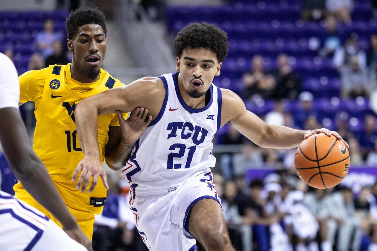 TCU guard Noah Reynolds (21) drives to the basket on West Virginia guard Sencire Harris (10) in the first half of an NCAA game between TCU and West Virginia at Schollmaier Arena in Fort Worth on Wednesday, Feb. 5, 2025.