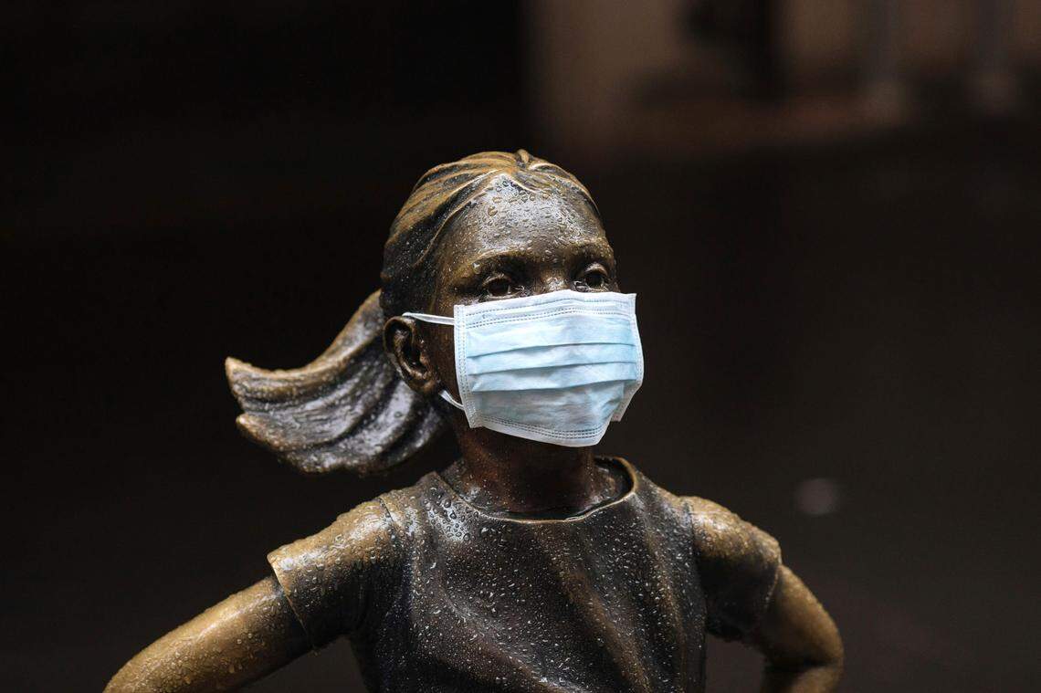 A surgical mask is placed on The “Fearless Girl” statue outside the New York Stock Exchange on Thursday, March 19, 2020, in New York.