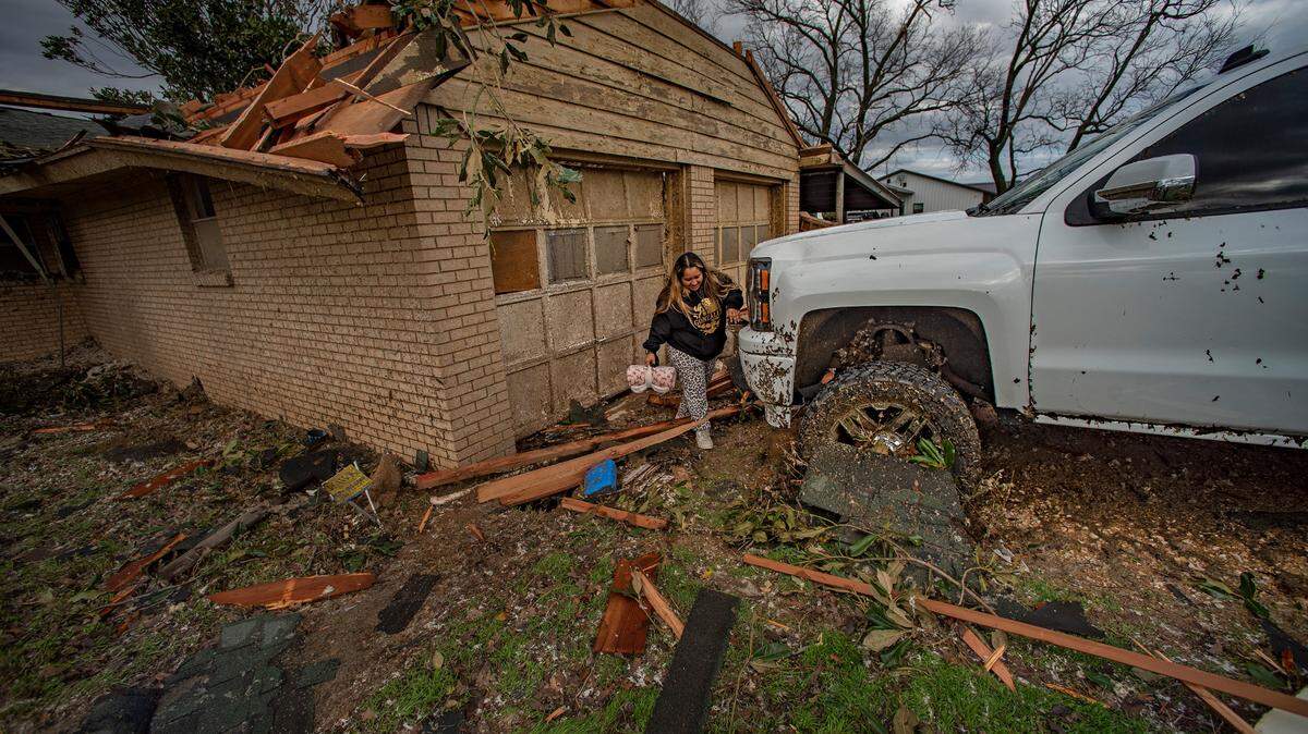 FILE -- Marisol Gonzalez checks on the damage on her truck. A tornado touched down just south of Decatur along FM 730 Tuesday, Dec. 13, 2022, tearing the roof off of a home and ripping trees in half.
