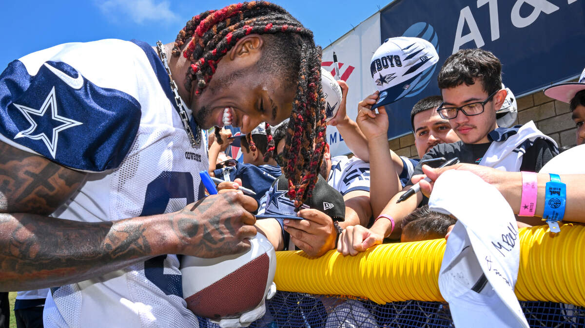 Dallas Cowboys wide receiver CeeDee Lamb signs autographs after the first day of training camp Wednesday in Oxnard, Calif.