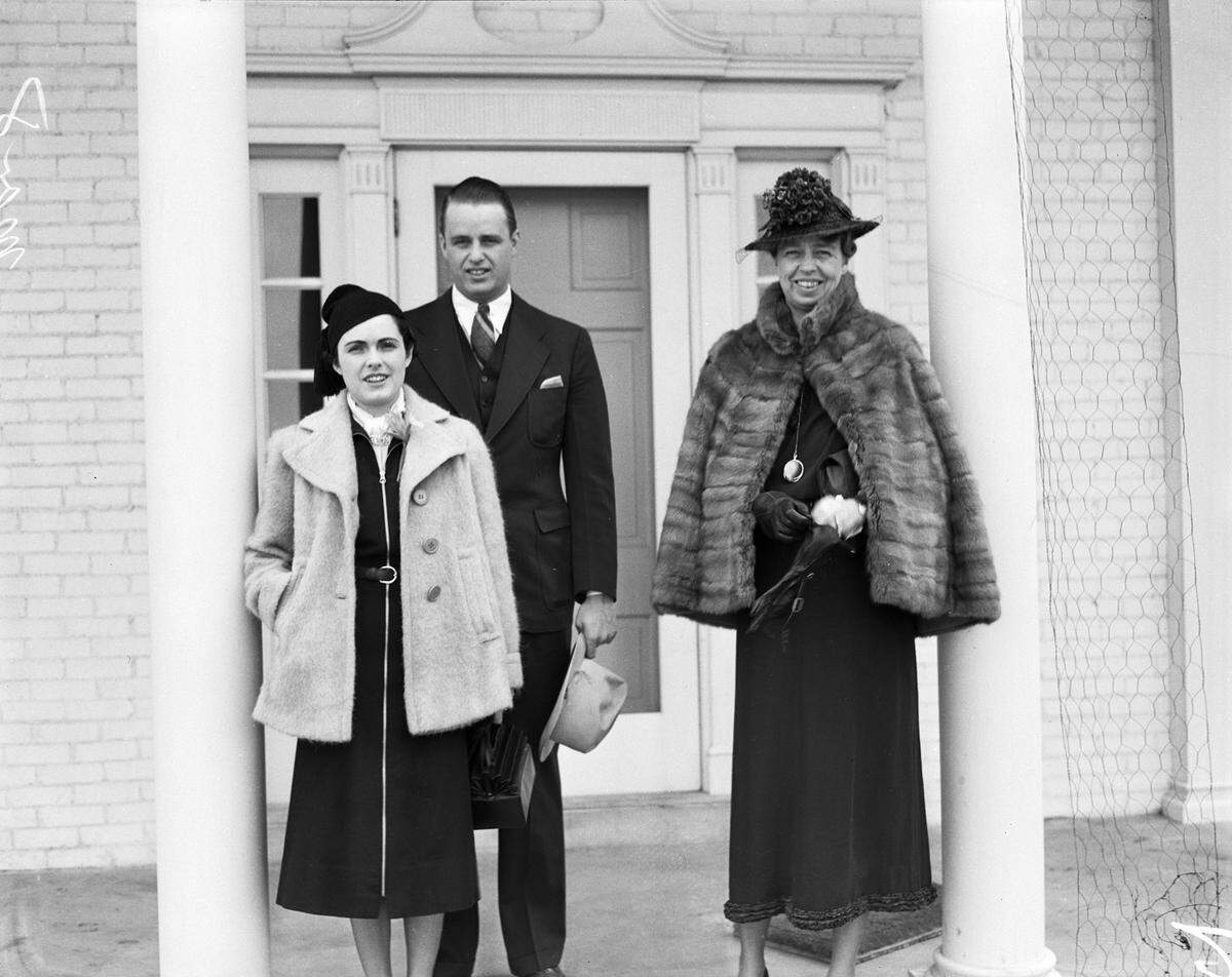 Ruth and Elliott Roosevelt standing on the front porch of their Dutch Branch Ranch home with First Lady Eleanor Roosevelt, right.