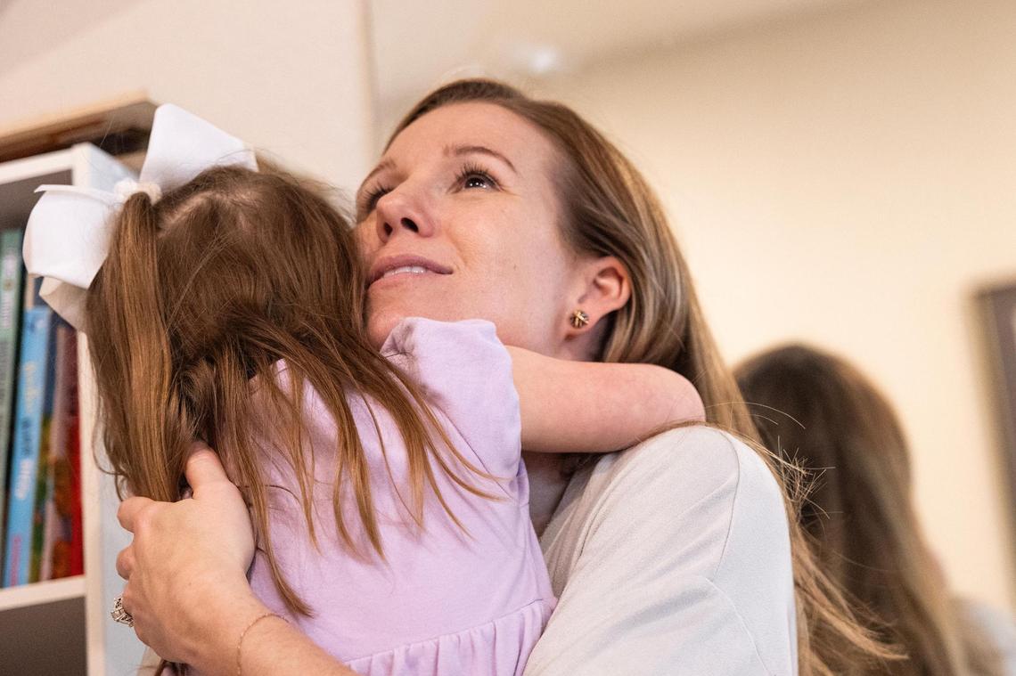 Courtney Morey hugs her daughter, Annie, in the upstairs play room of their home in North Texas on Friday, March 28.
