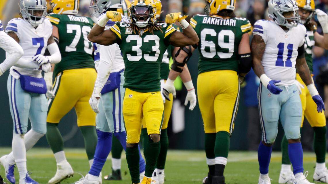 Green Bay Packers running back Aaron Jones (33) celebrates after running the ball for a first down as Dallas Cowboys cornerback Trevon Diggs (7) and linebacker Micah Parsons (11) walk past during Sunday’s game at Lambeau Field.