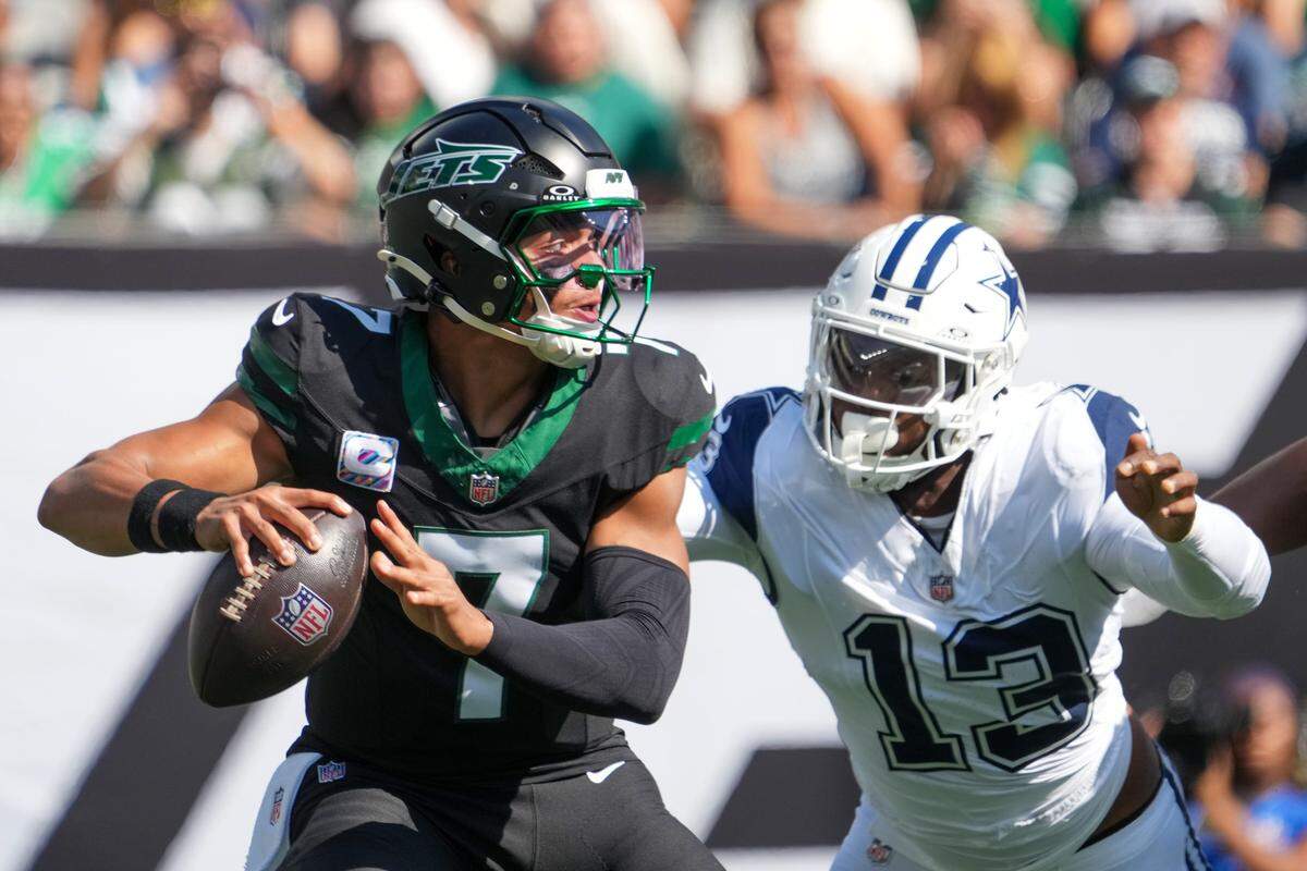 Oct 5, 2025; East Rutherford, New Jersey, USA; New York Jets quarterback Justin Fields (7) is pressured by Dallas Cowboys defensive end Dante Fowler Jr. (13) during the first half at MetLife Stadium. Mandatory Credit: Robert Deutsch-Imagn Images