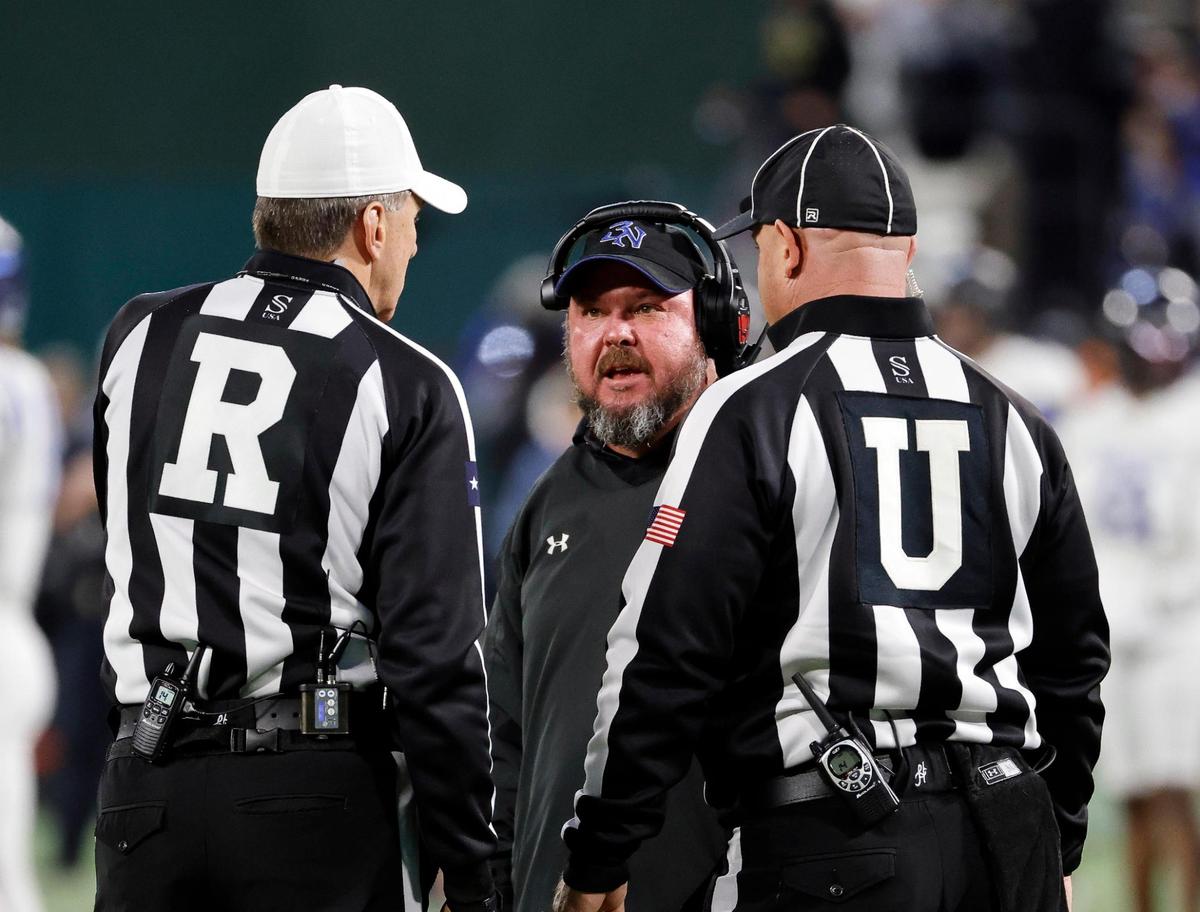 Byron Nelson head coach Travis Pride talks to the umpire and referee during a timeout in the first half of a UIL Conference 6A Division 2 quarterfinal football playoff game at Choctaw Stadium in Arlington, Texas, Saturday, Dec. 02, 2023.