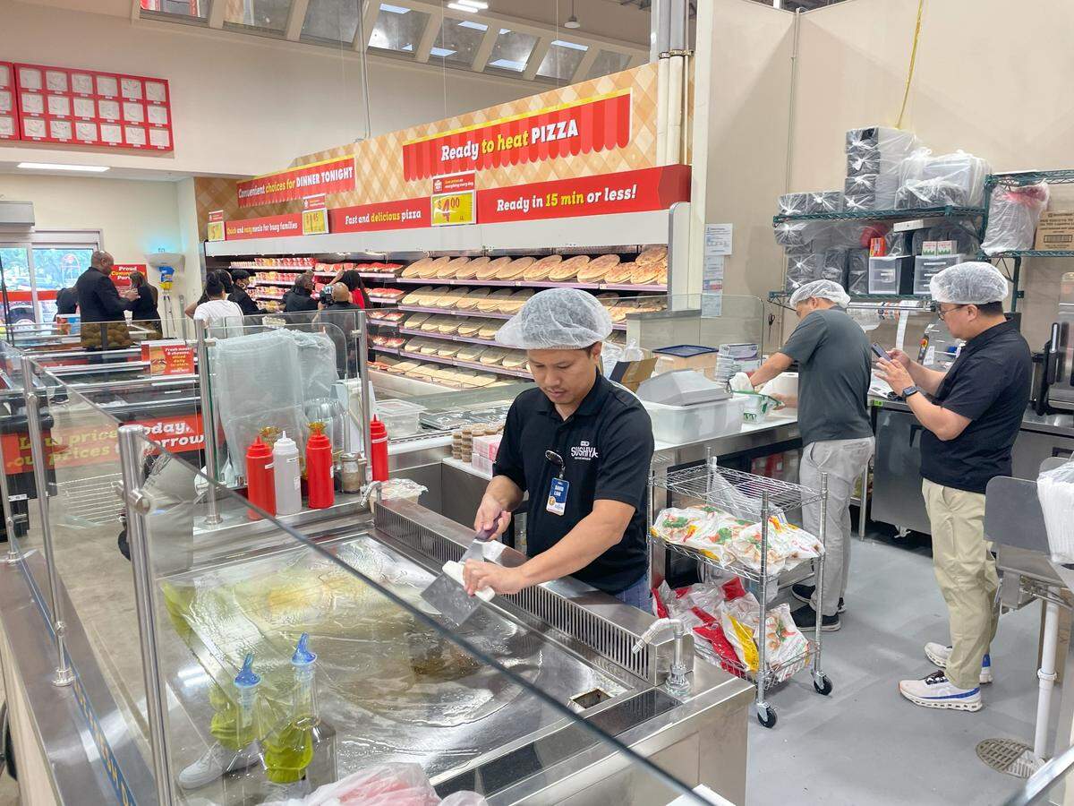 A worker at Joe V's Smart Shop prepares the store's sushi making station. 