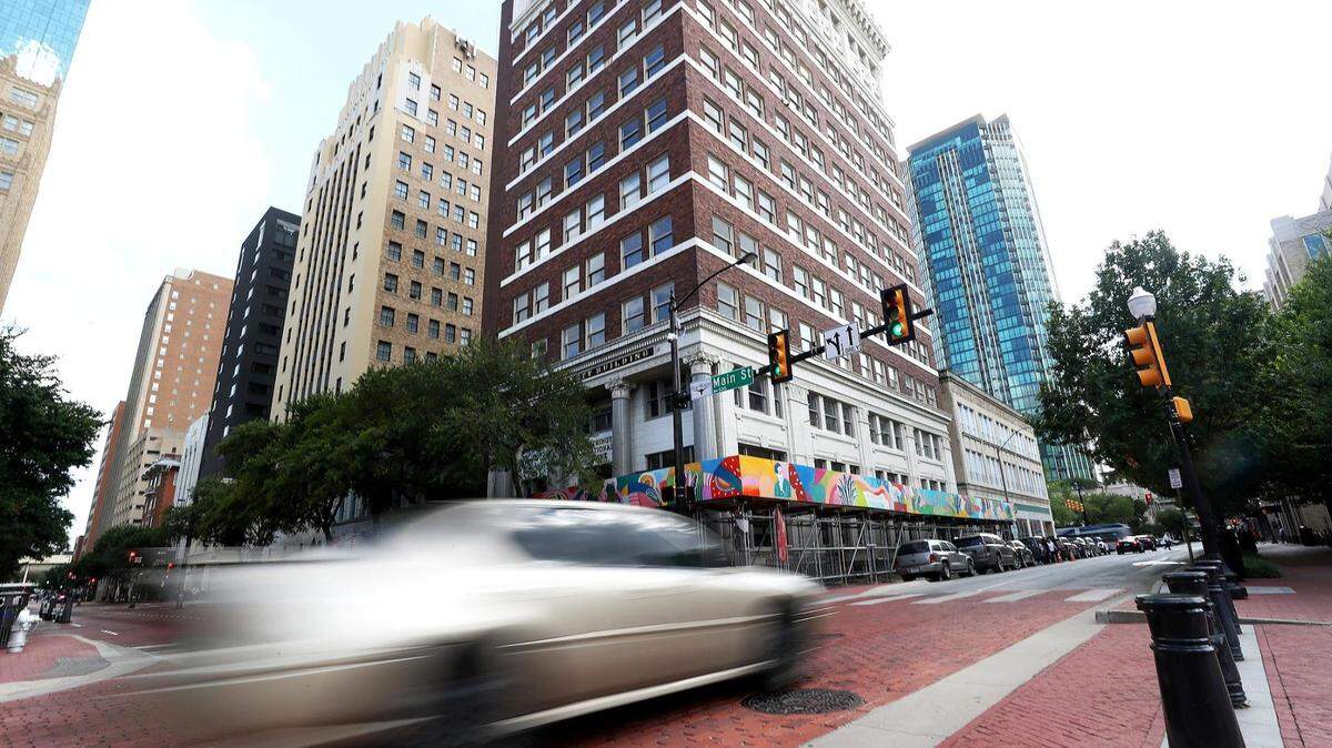 A car drives down West 4th Street in downtown Fort Worth, the No. 16 hardest working city in America.