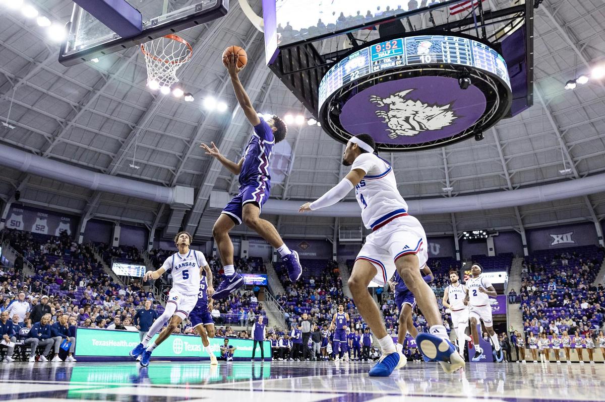 TCU guard Noah Reynolds (21) drives for a layup between Kansas defenders in the first half of an NCAA game between TCU and Kansas at Schollmaier Arena in Fort Worth on Wednesday, Jan. 22, 2025.