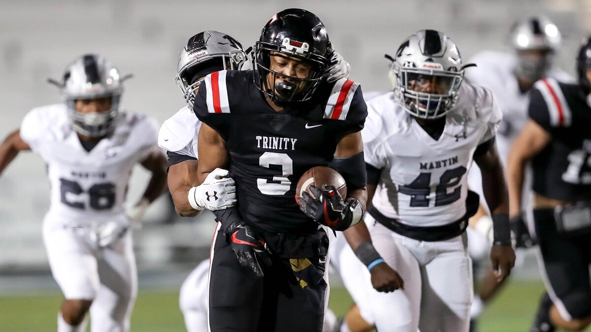 Euless Trinity running back Brandon Theus (3) fights for yardage against Arlington Martin during the first half Friday night in the 6A Division I bi-district playoff game at Pennington Field in Bedford. Trinity won 56-34.