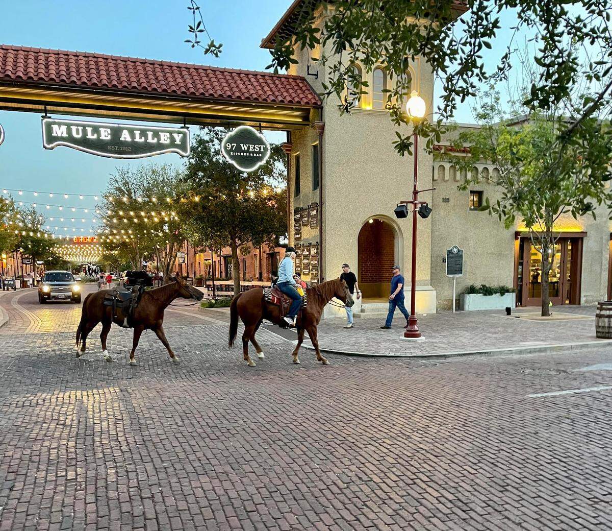 A pair of horses pass the entrance to Mule Alley in the Fort Worth Stockyards on Sept. 8, 2022.