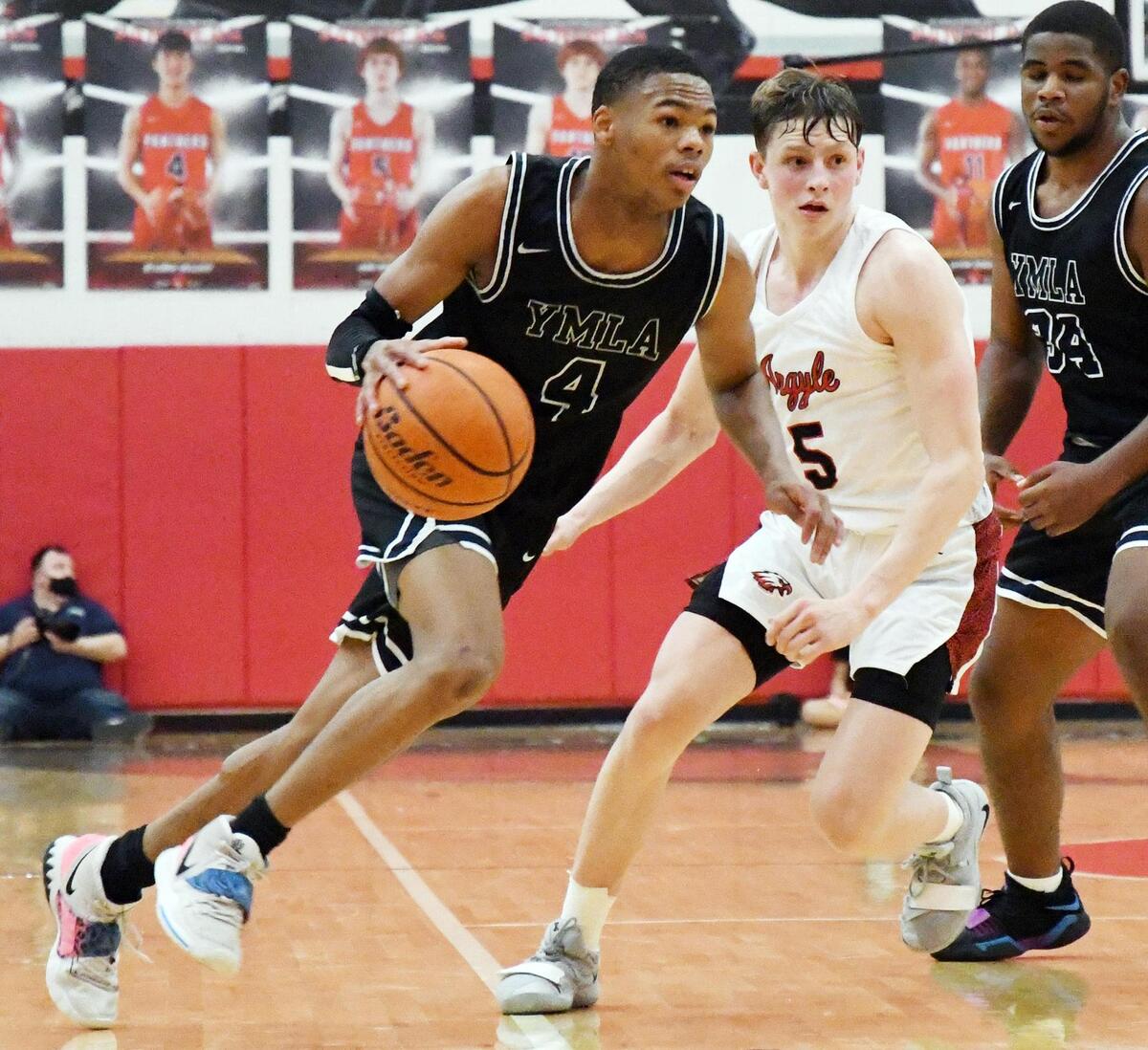 Young Men’s Learning Academy’s D’Monyae Davis, left takes the ball up the court past Argyle’s Slate McMellian during the fourth period of their 4A Region I Quarterfinal playoff game Saturday, February 27, 2021 at Colleyville Heritage High School in Colleyville, Texas. Argyle went on to win 49-40. Special/Bob Haynes