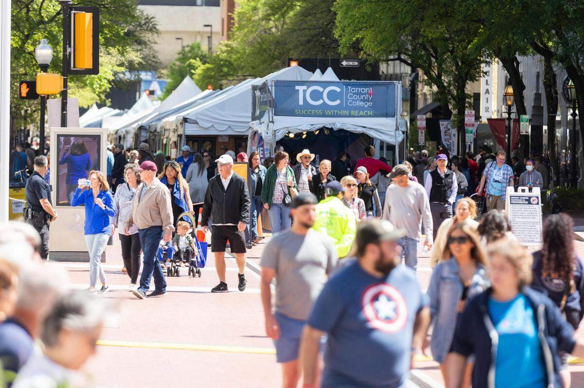Festival goers walk through Sundance Square where the Fort Worth Arts Fair is taking place along with the Main Street Fort Worth Arts Festival on the street Thursday, April 7, 2022, in downtown Fort Worth.
