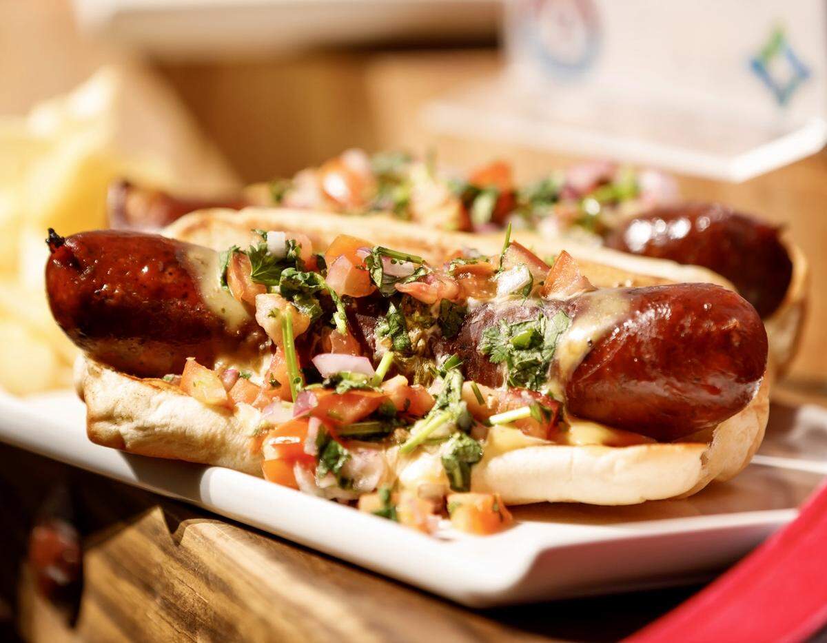 The Hurtado Barbecue poblano sausage “Oaxaca Dawwg” with queso and pico. It’s a special item for a 2023 playoff sites.