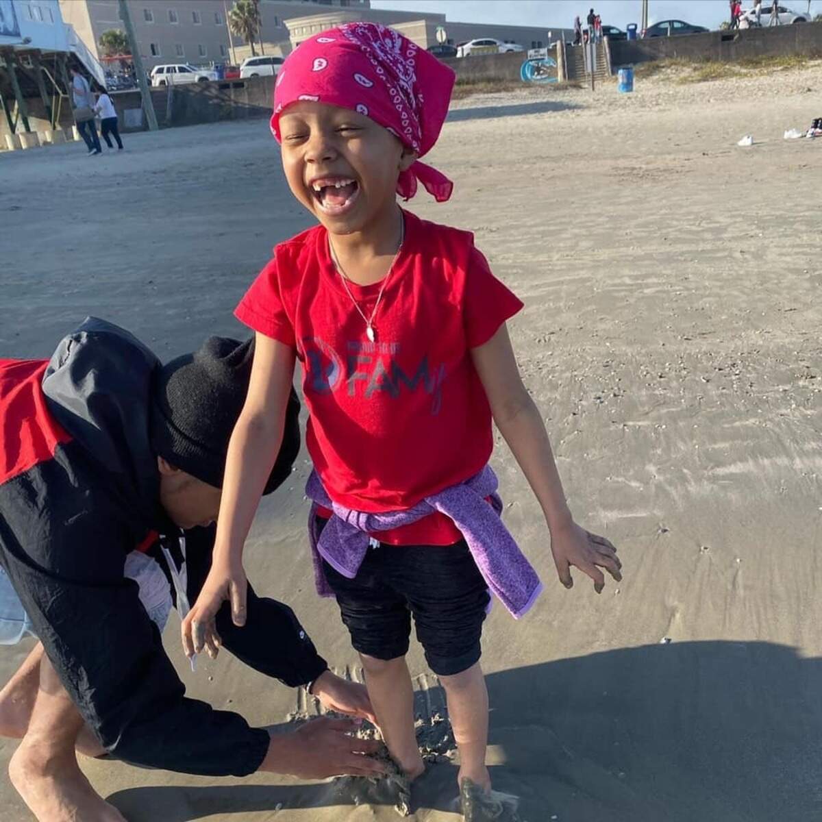 Adriana Nixon smiles with her feet in the wet sand of a beach in Houston. She and her family have taken sporadic trips as they have dealt with her liver cancer, trying to give her fun times and memories.