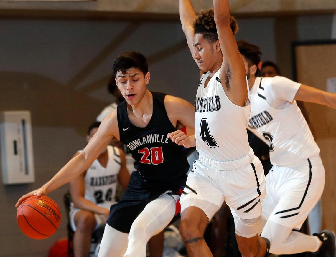 Mansfield guard Marquis Thibert (4) defends against Duncanville guard Juan Reyna (20) during the first half of a 6A Region 1 quarterfinal basketball game at Arlington ISD Athletics Complex in Arlington, Texas, Saturday, Feb. 27, 2021. Duncanville led 38-23 at the half. (Special to the Star-Telegram Bob Booth)