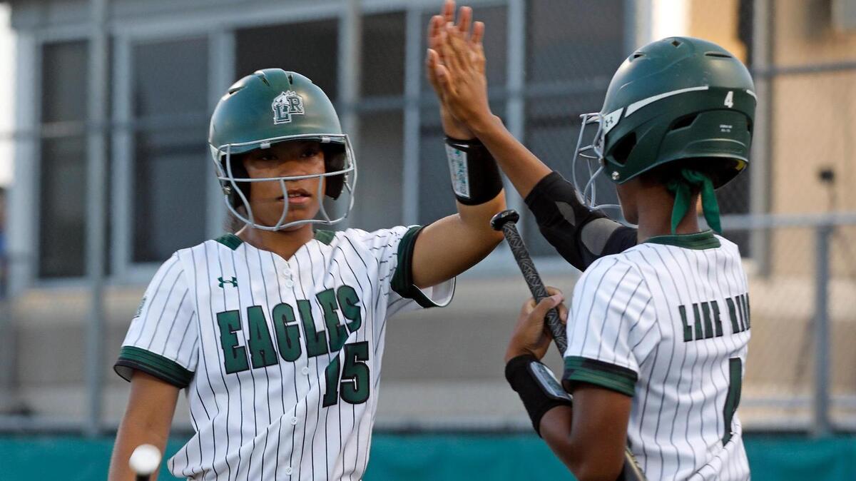 Lake Ridge short stop Kassidy Chance (4) high fives second baseman Madison Barnes (15) after Barnes tied the game on a double by center fielder Tia Warsop (5) during a UIL 6A Region 2 area round softball name at Lake Ridge High School in Mansfield, Texas, Friday, May 06, 2022. Lake Ridge defeated Tyler Legacy 6-3 on 16 hits and no errors to move on to the next round. (Special to the Star-Telegram Bob Booth)