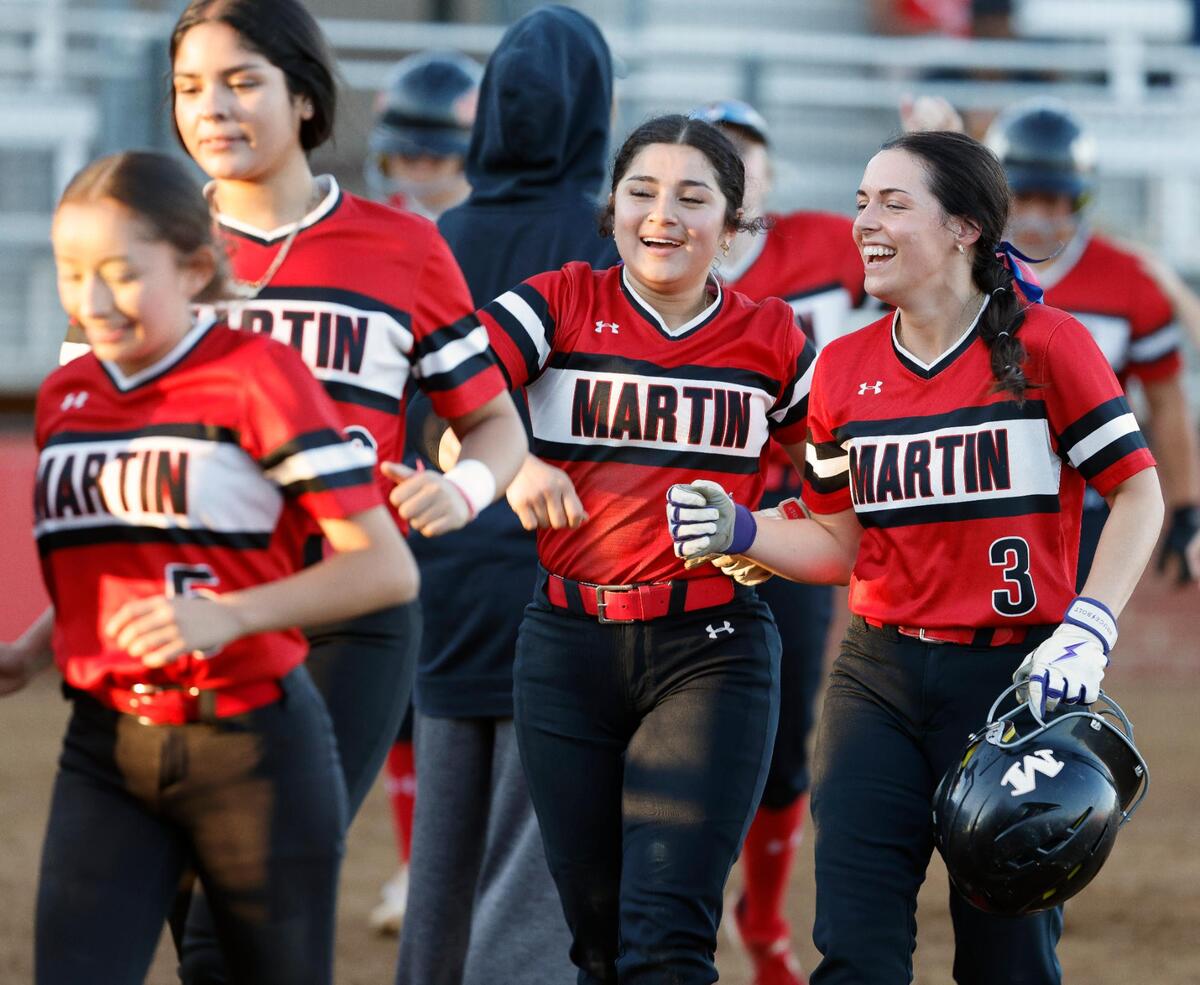 Arlington Martin short stop (4) Izabella Martinez (center) celebrates a team mates home run during their game against Arlington at the Workman Softball Complex in Arlington Texas, Friday Mar. 23, 2024.