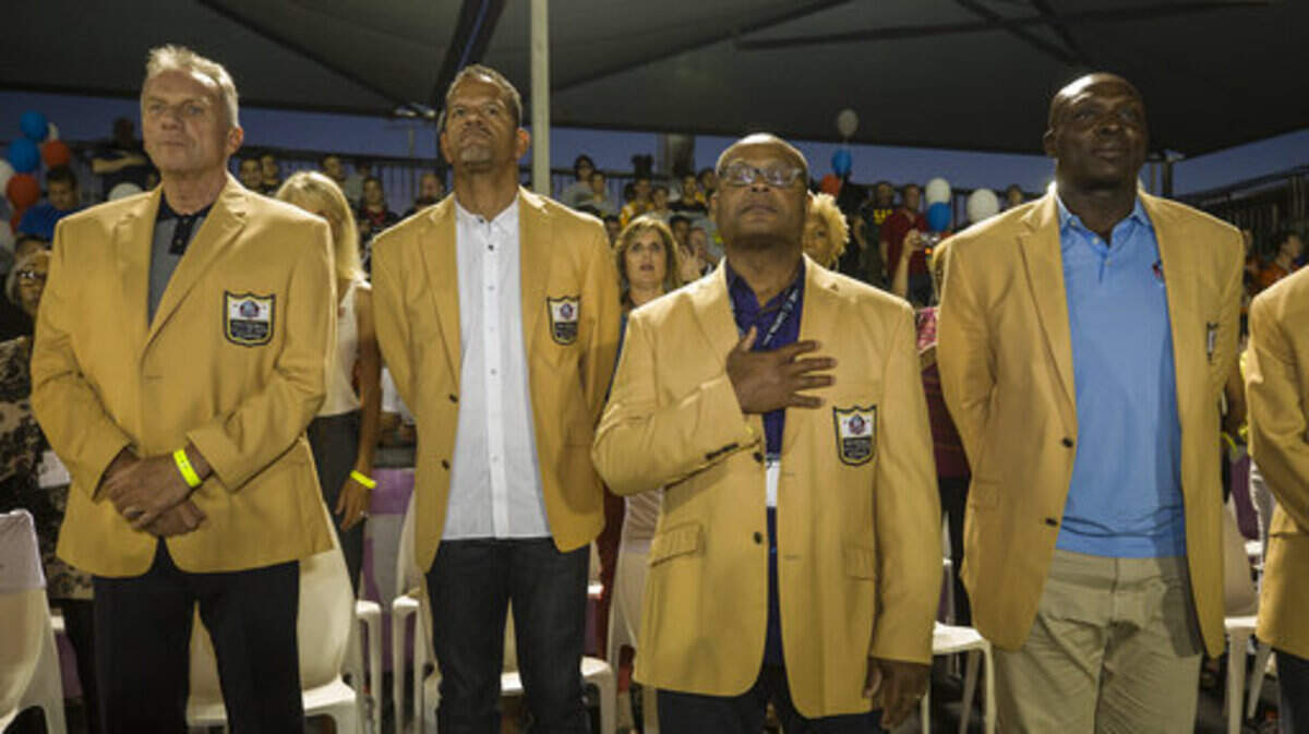 NFL Hall-of-Famer Mike Singletary (middle) has been named the new head football coach at Trinity Christian-Addison.