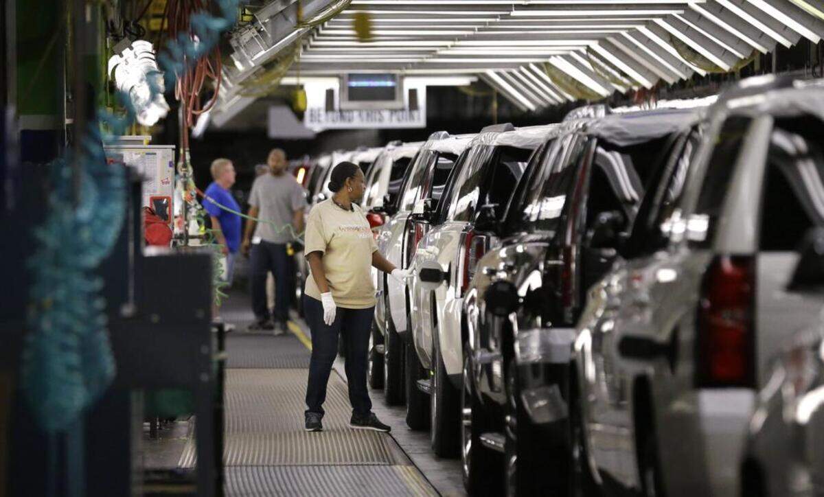 An auto worker inspects finished SUVs at General Motors’ Arlington plant.