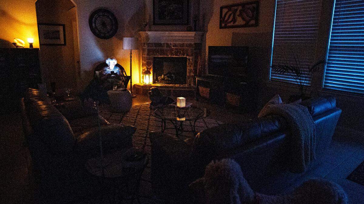 The frigid weather that blanketed Texas has taxed the state’s power grid forcing the utility companies to implement rolling blackouts. The scene inside a Granbury home during a power loss just as the sun sets for the day Feb. 16, 2021. Illuminated by candlelight and reading on an iPhone, a resident waits for the power to be restored.