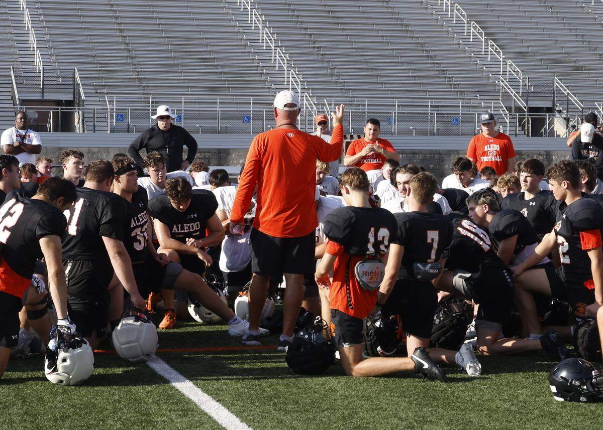 The Bearcats listen to head coach Robby Jones after morning practice at Tim Buchanan Stadium in Aledo, Texas, Monday August, 18, 2025.