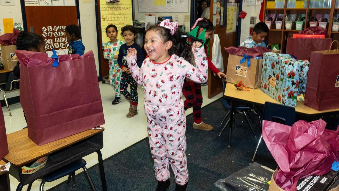 Kindergarten students react to seeing their Christmas presents laid out for them on their desks in Oralia Flores’ classroom at Alice Contreras Elementary School in Fort Worth on Thursday, Dec. 19, 2024.
