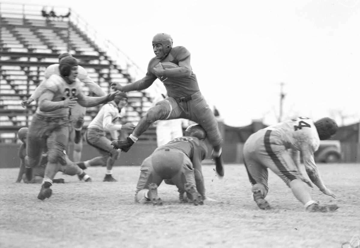 Ray Mallouff, Southern Methodist University, hurdling a fallen team mate during the TCU vs SMU football game in 1940.