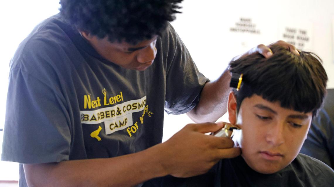 Kaylen Jordan, 15, straightens the side burns of Ivan Gonzalez, 15, while attending Next Level Barber and Cosmo camp in Fort Worth. The camp focuses on teaching trade skills, entrepreneurship and self-confidence.