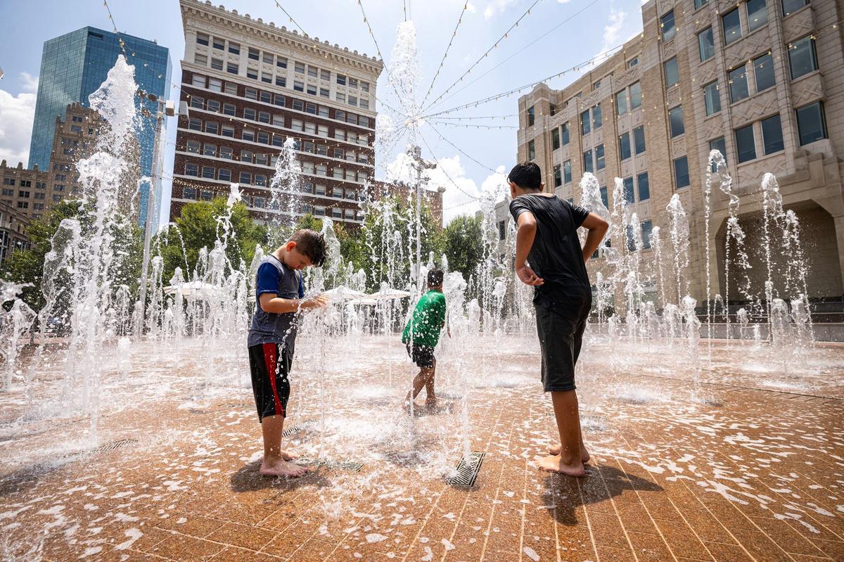 Hans Jenseth, 7, left, and brothers Phoenix, 6, and Noah Earle, 12, play in the fountains at Sundance Square go off at Sundance Square Plaza in downtown Fort Worth on Wednesday, July 24, 2024.
