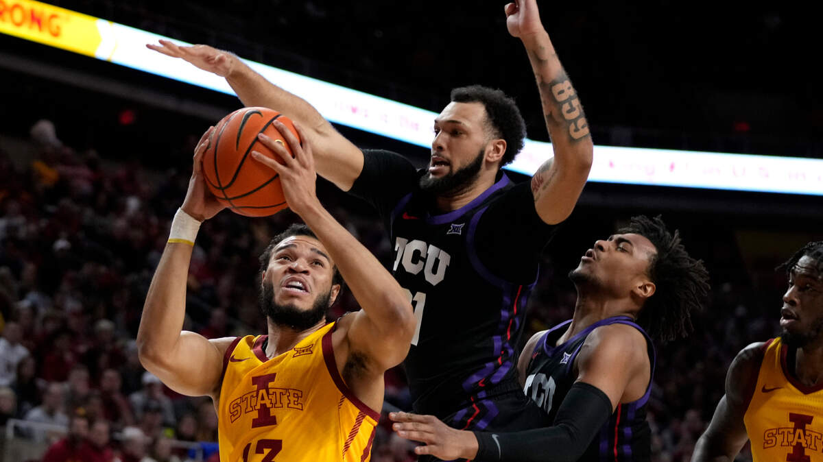 Iowa State guard Jaren Holmes (13) drives to the basket past TCU forward JaKobe Coles, center, and forward Chuck O’Bannon Jr., right, during their game Wednesday in Ames, Iowa.