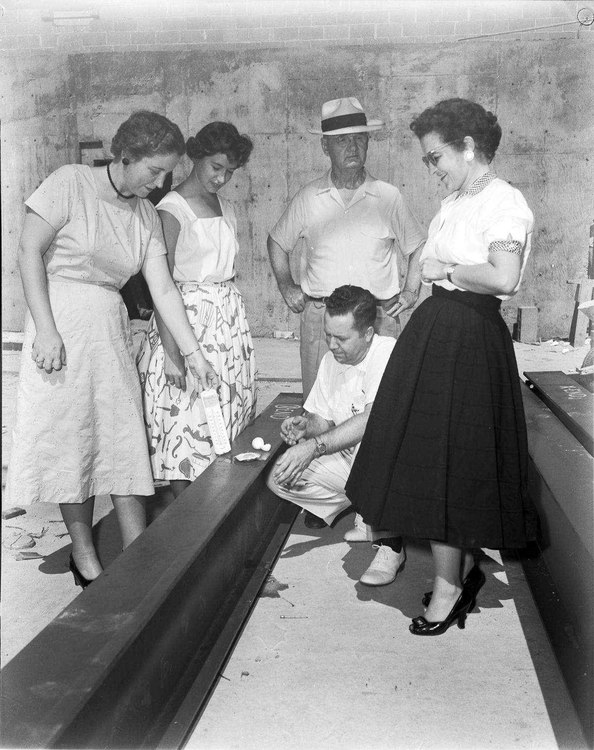 Group frying egg outside at the bank where they work on hotest day of year, temperature at 108-109 degrees, 07/12/1954