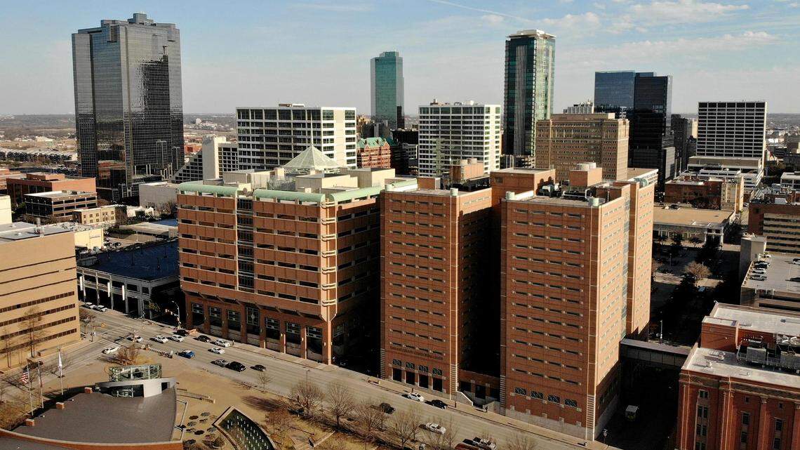 A view of the Tarrant County Jail with Fort Worth's downtown skyline behind it.