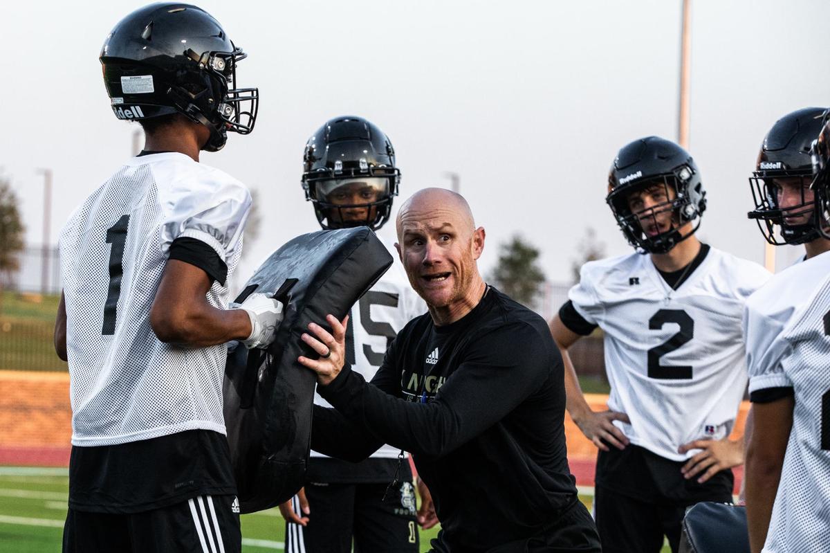 Head Coach Jeremy Mullins gives a demonstration to players on Monday, August 5, 2024, at Eagle Mountain High School.