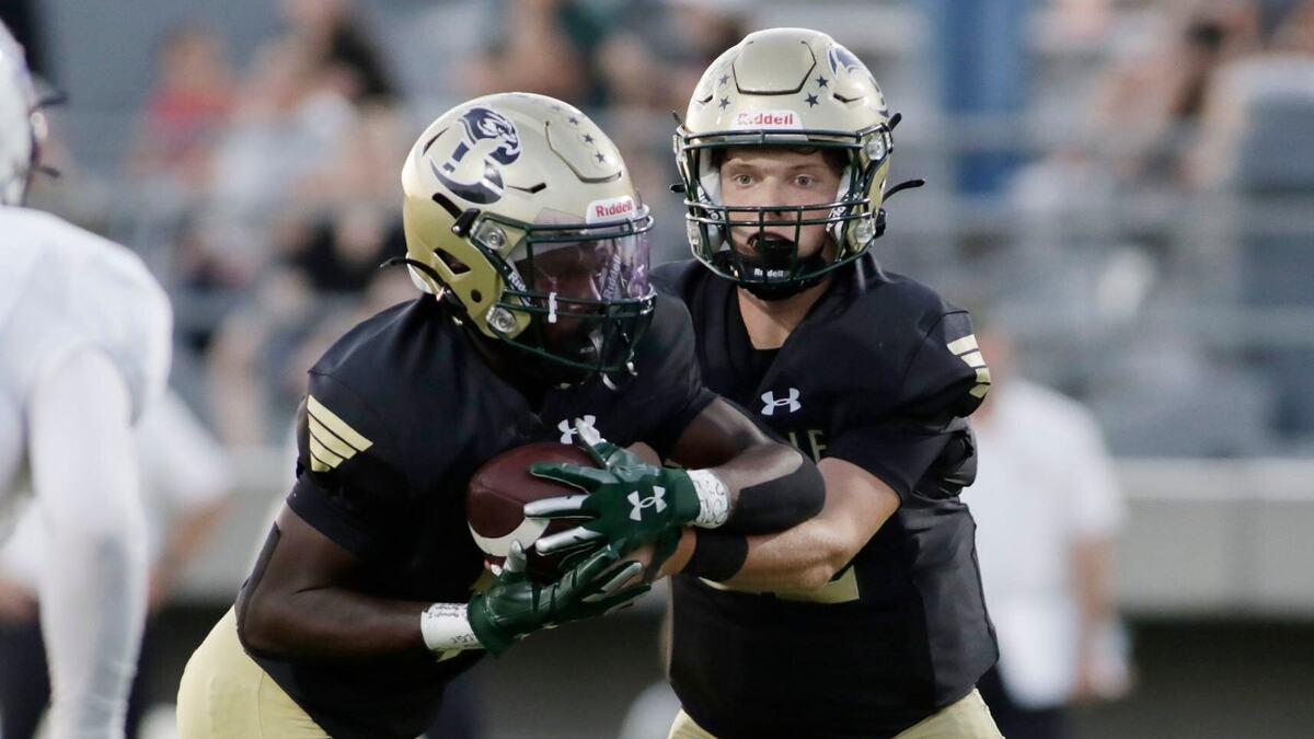 Birdville’s Zach Wells hands off to Lamar Leggins as they take on Grandbury during their game Thursday night at the Birdville Athletic Center. JOHN ROWLAND