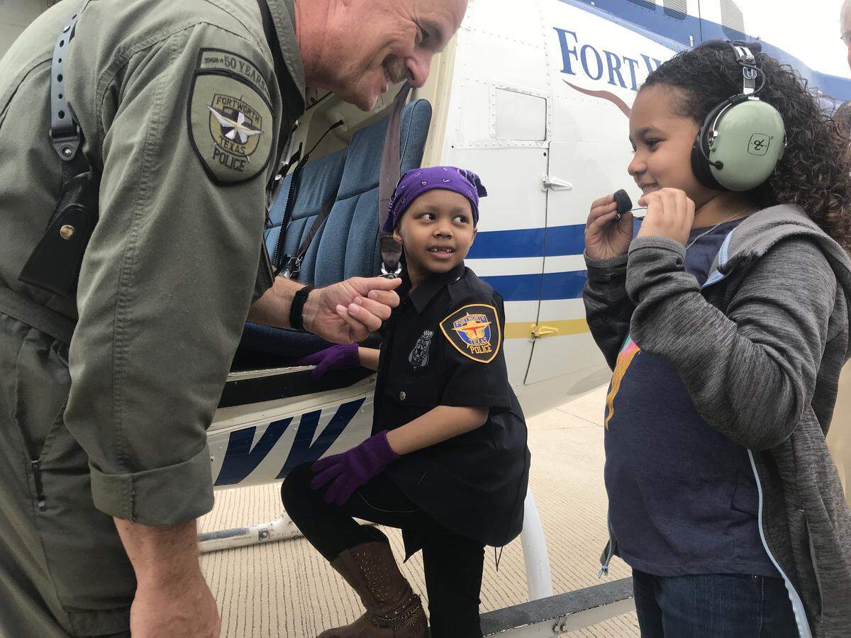 Adriana Nixon (center), 6, prepares to board a Fort Worth police helicopter with her sister, Alana Nixon (right), 9. She was sworn in as an honorary police officer for a day in a ceremony at the department headquarters.