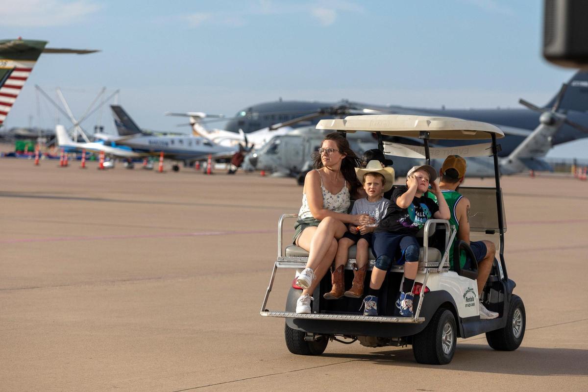 A family leaves the AllianceTexas Aviation Expo presented by Bell at the Fort Worth Alliance Airport in Fort Worth on Saturday, Oct. 22, 2022. The performance featured several different aircrafts performing complicated maneuvers.