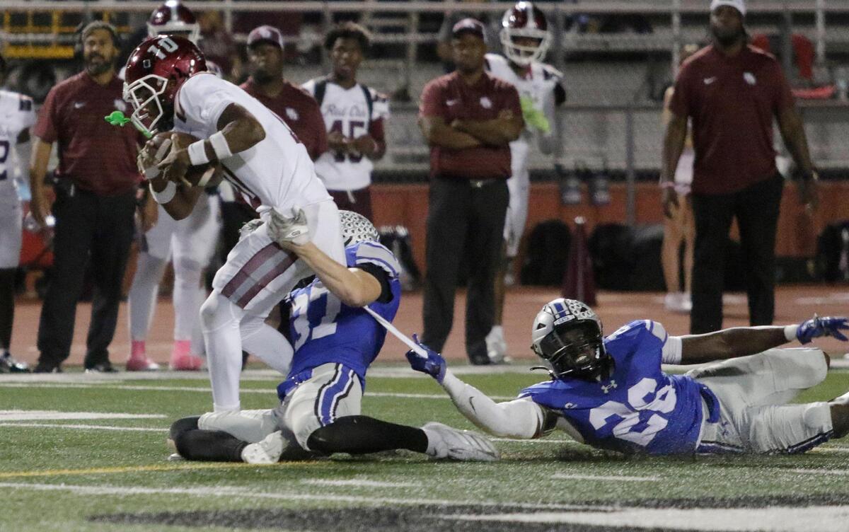 Red Oak’s Billy Middleton is dragged down by Burleson’s Andrew Hoffman and Meziah Ababio during a UIL football game at Burleson ISD Stadium on Friday October 25, 2024.