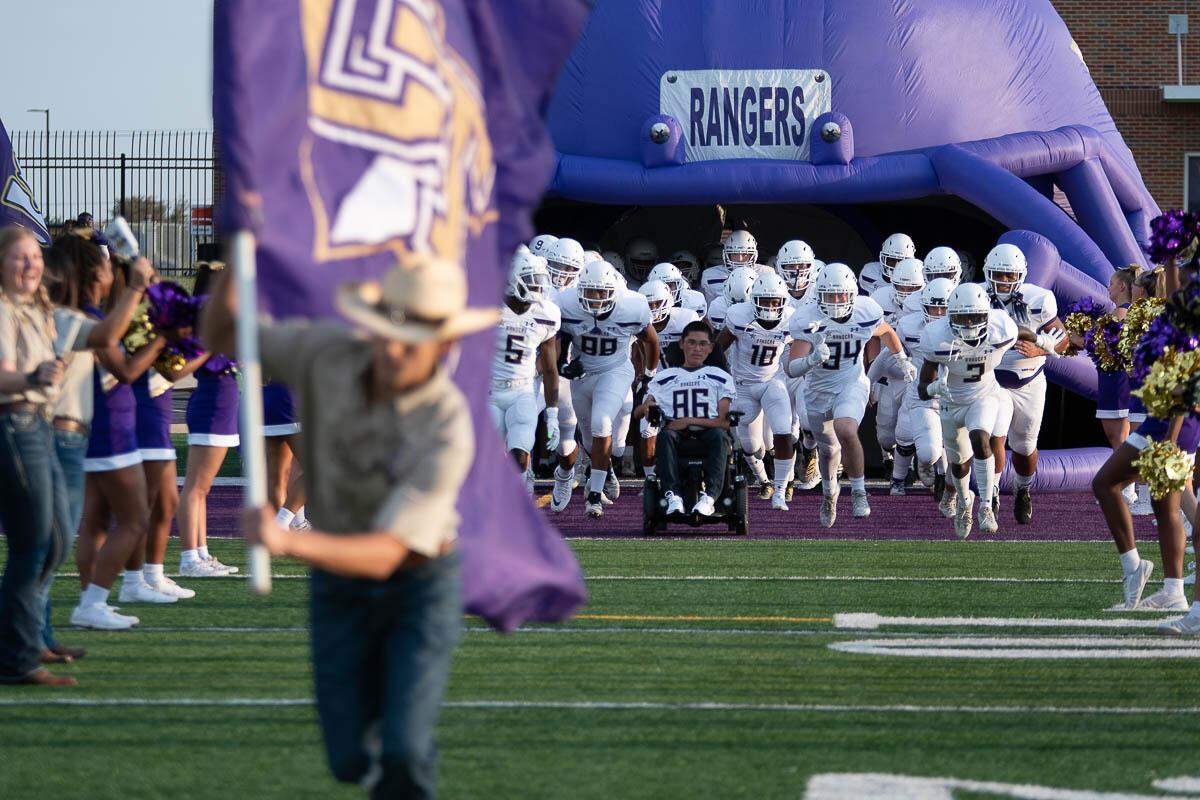 Saginaw Chisholm Trail Xavier Hernandez, who suffers from muscular dystrophy, leads the football team onto the field.