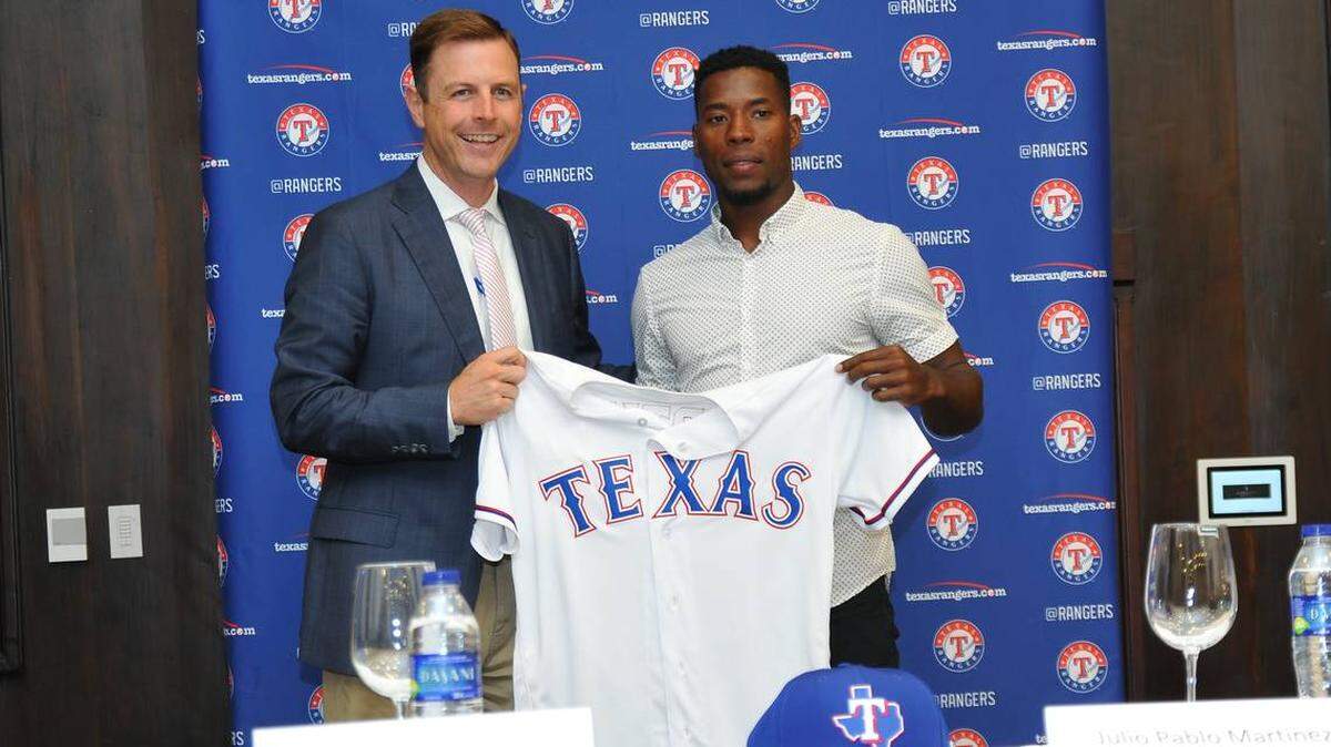 Rangers assistant general manager Mike Daly, left, said that Julio Pablo Martinez's first assignment in the United States will be with the short-season Class A team in Spokane, Wash.