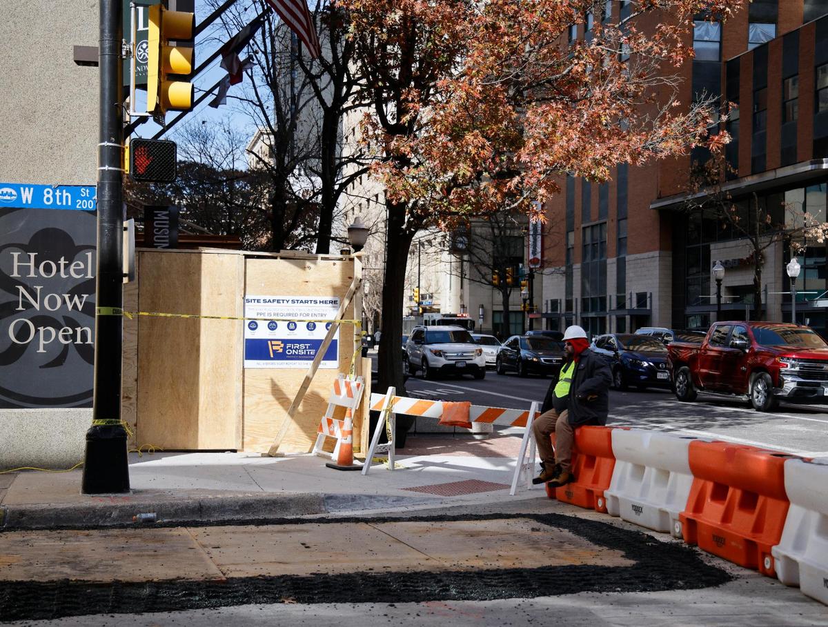 A security guard sits at Houston Street and Eighth Street on Saturday after Houston Street was opened following cleanup from the explosion in the Sandman Signature Hotel in downtown Fort Worth. Twenty-one people were injured in the explosion and one remains in critical condition.