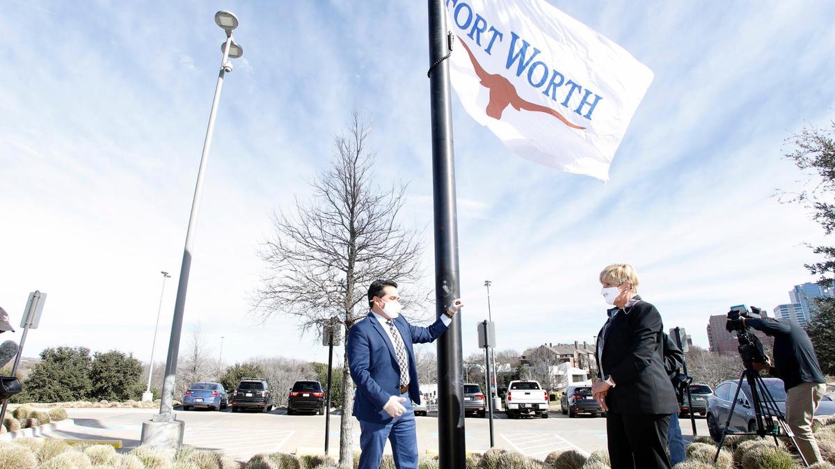 Fort Worth District 2 Councilman Carlos Flores takes his turn at raising the city flag as mayor Betsy Price looks on during the announcement of Fort Worth’s new city hall in Fort Worth, Texas, Tuesday, Feb. 02, 2021. The city purchased the previous Pier 1 building for their new city hall. The only major remodel they will do is for the council chambers. (Special to the Star-Telegram Bob Booth)