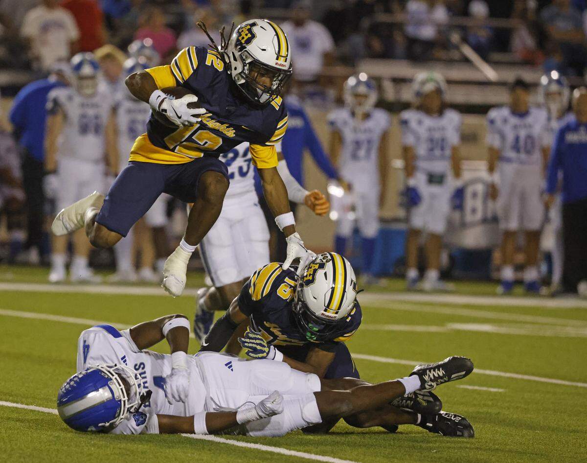 Arlington Heights wide receiver Yakeime Thomas (12) jumps over the pile before getting tackled during the first half of a UIL Conference 5A D1 Bi-District playoff game between Arlington Heights and Brewer at Farrington Field in Fort Worth, Texas, Friday, Nov. 14, 2025.