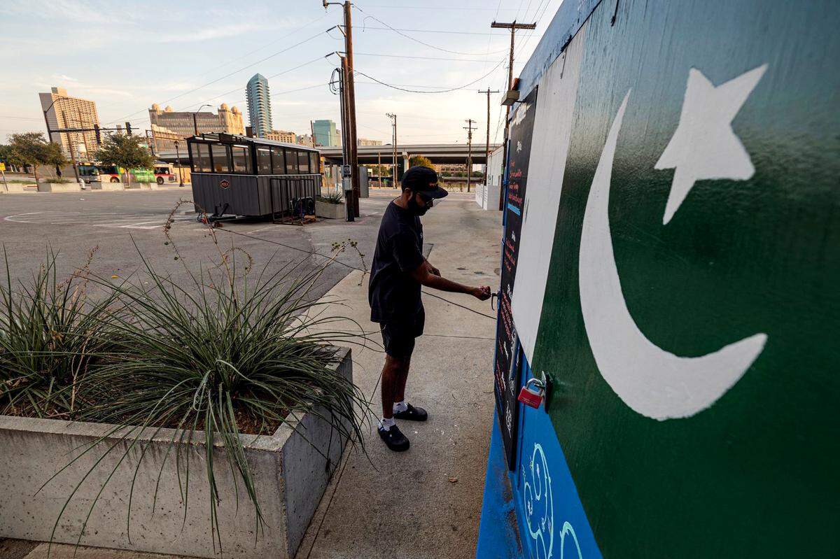 Zain Shafi, the owner of Sabar BBQ, writes the menu and unlocks the trailer parked at the corner of East Vickery Boulevard and South Main Street near downtown Fort Worth on Saturday, Aug. 23, 2024. 