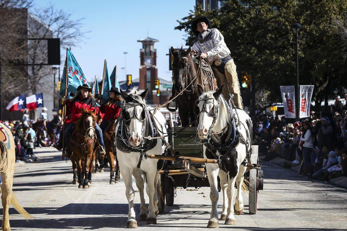 A cowboy and his horse ride on a horse-drawn wagon for the Fort Worth Stock Show and Rodeo parade Saturday Jan. 18, 2020, in downtown Fort Worth.