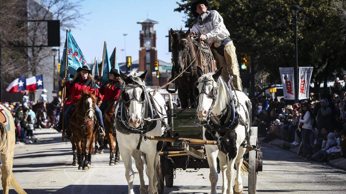 A cowboy and his horse ride on a horse-drawn wagon for the Fort Worth Stock Show and Rodeo parade Saturday Jan. 18, 2020, in downtown Fort Worth.