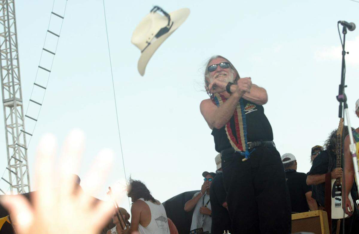 PHOTO FOR METRO *** Willie Nelson tosses his hat into the crowd after playing with Pauline Reese at his 32nd, 4th of July Picnic in the historic Fort Worth Stockyards in Fort Worth Monday, July 4, 2005. (STAR-TELEGRAM/JEFFERY WASHINGTON)