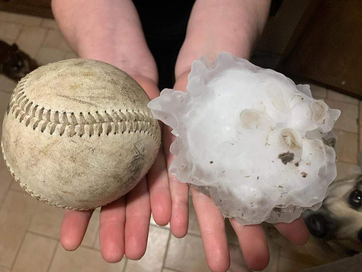 Burkburnett resident Angie McCoy holds out a hailstone as large as a softball on Thursday evening. Hail pummeled the area Thursday evening, with the largest reported hail measuring at 5 and 1/3 inches, larger than softball-size, according to the National Weather Service in Norman, Oklahoma.