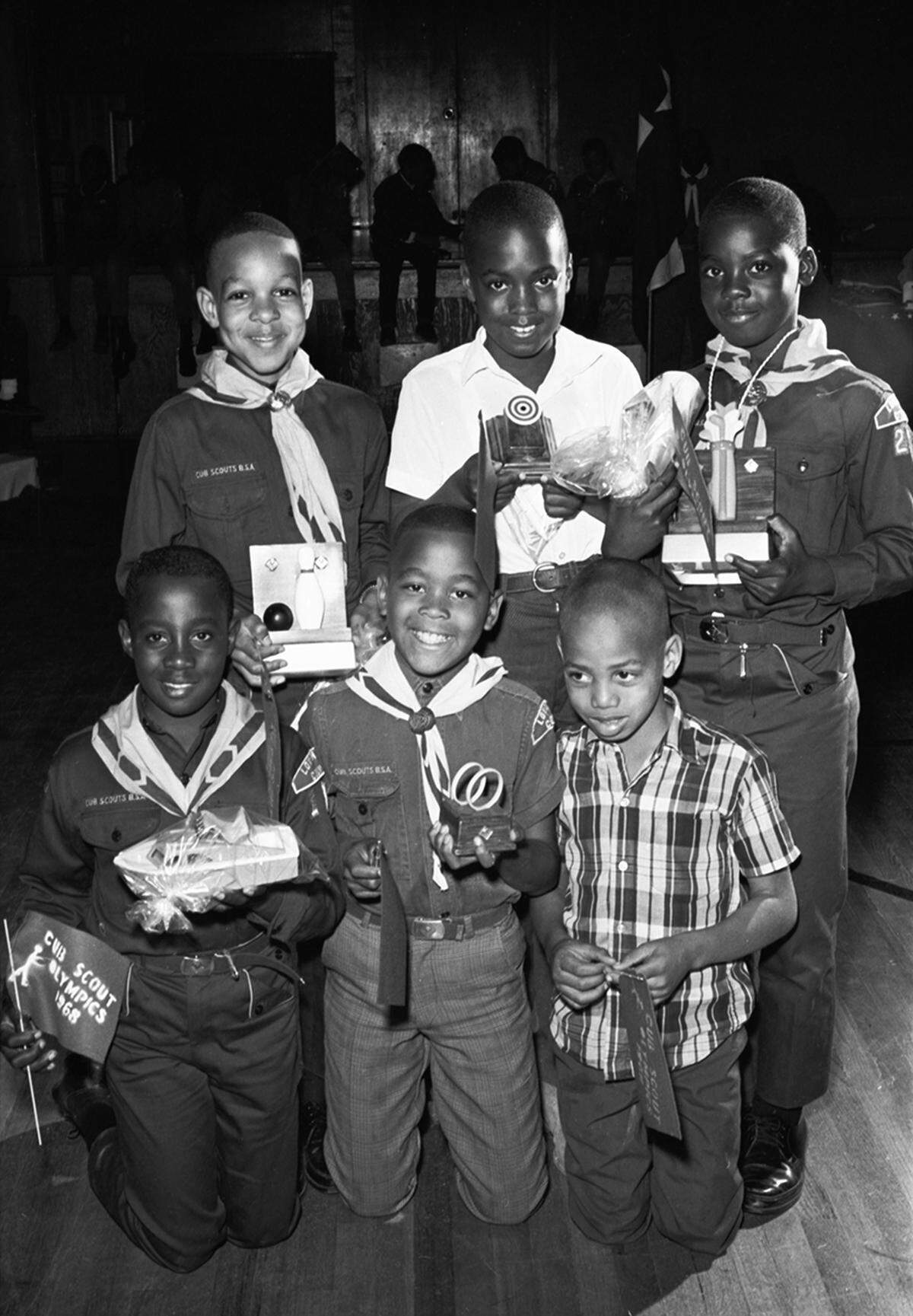 March 2, 1968: A group of children at the 1968 Cub Scout Olympics, held by the Woodbine Trail District Longhorn Council of the Boy Scouts, holding flags and various trophies. The event was held in Harmon Recreation Center in Fort Worth and was attended by about 100 cub and boy scouts. Cub Scout Pack 231, represented by Kirkpatrick Elementary school students Dale Brown, 10, Anthony Earle, 9, and Marcus Jones, 9, won the hoop race. Arbra King, 10, won the bowling competition and Robert Knox, 11, won the putting competition.